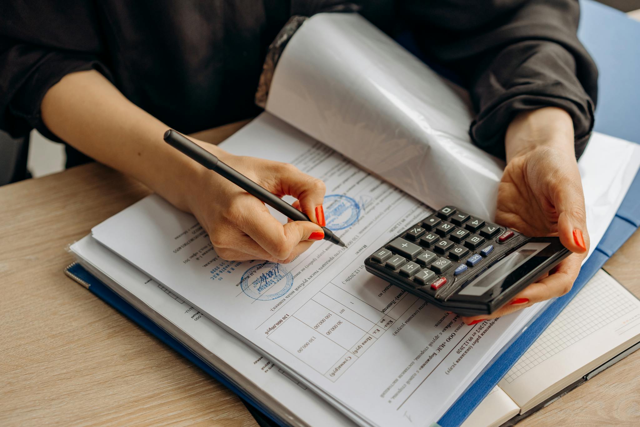 an accountant using a calculator and signing